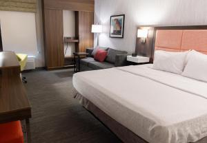 a hotel room with a bed and a couch at Hampton Inn Williamsport in Williamsport +19 photos