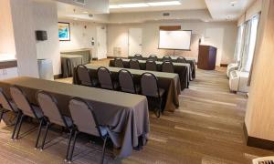 a conference room with tables and chairs and a screen at Hampton Inn Williamsport in Williamsport