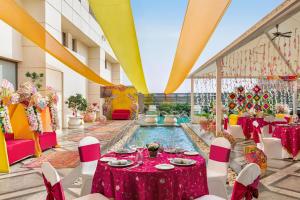 a banquet hall with a pool and tables and chairs at Hilton Jaipur in Jaipur