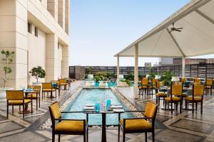 a restaurant with a pool on the roof of a building at Hilton Jaipur in Jaipur