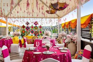 a room with pink tables and white chairs and a tent at Hilton Jaipur in Jaipur +50 photos