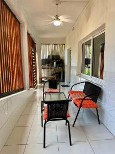 two chairs and a table in a room with windows at villa Moissuli par chambre in Mtsamboro