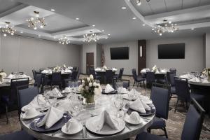 a dining room with tables and chairs and tablesktop at Embassy Suites by Hilton Jackson North Ridgeland in Ridgeland