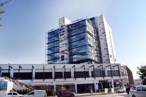 un edificio alto con coches estacionados frente a él en Ostimpark Business Hotel en Ankara