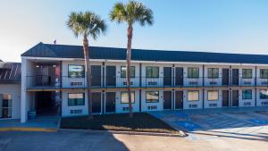 a building with palm trees in front of it at Red Roof Inn Slidell in Slidell