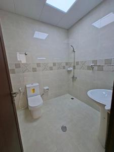a bathroom with a toilet and a sink at Easy Stay in Al Ain