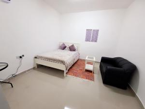 a white room with a bed and a couch at Easy Stay in Al Ain