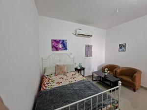 a small bedroom with a bed and a couch at Easy Stay in Al Ain