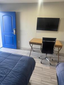 a room with a desk and a blue door at Clover motel in Lynwood