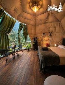 a room with a bed and a table in a tent at Cerro Verde Glamping Cartago in Lourdes