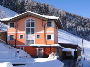 a house covered in snow with a mountain in the background at Sonnenwinkel I in Kolsassberg