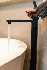 a person holding a cell phone next to a bathtub at Hotel Agua de Plata in San Luis Potosí