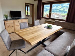 a living room with a wooden table and chairs at Nachtschatt in Fügen