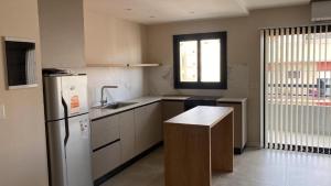a kitchen with a refrigerator and a sink in it at C&R Departamentos y Hoteles in Mar del Plata
