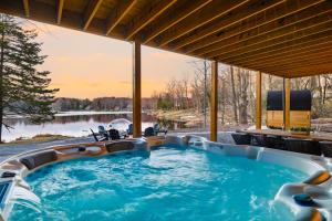 a jacuzzi tub with a view of a lake at The Four Seasons Escape in Pocono Lake