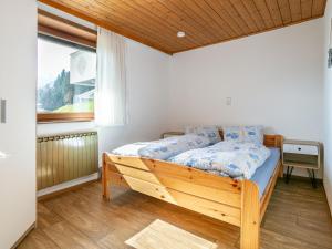 a bedroom with a wooden bed with a window at Nachtschatt in Fügen