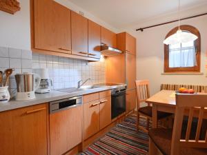 a kitchen with wooden cabinets and a wooden table with a dining room at Apartment Gartentraum in Itter