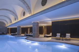 a large swimming pool with chairs and tables in a building at Waldorf Astoria Jerusalem in Jerusalem