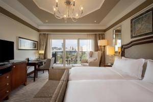 a hotel room with two beds and a desk at Waldorf Astoria Jerusalem in Jerusalem