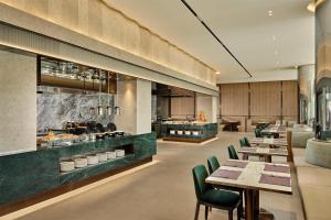 a restaurant with wooden tables and green chairs at Hilton Gyeongju in Gyeongju