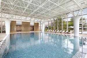 a large swimming pool with chairs in a building at Hilton Gyeongju in Gyeongju
