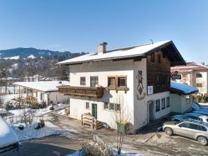 a house in the snow with a car parked in front at Haslau Large in Hopfgarten im Brixental