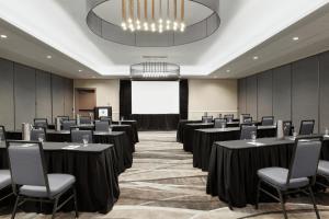 a conference room with tables and chairs and a projection screen at Embassy Suites by Hilton Arcadia-Pasadena Area in Arcadia