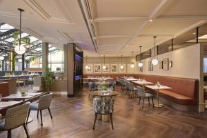 a restaurant with tables and chairs and a bar at Hilton Leeds City in Leeds