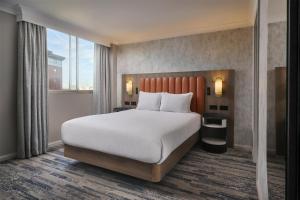 a bedroom with a large bed and a large window at Hilton Leeds City in Leeds