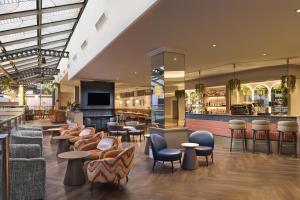 a lobby with chairs and tables and a bar at Hilton Leeds City in Leeds