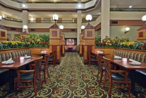 a restaurant with wooden tables and chairs and plants at Embassy Suites Lexington in Lexington