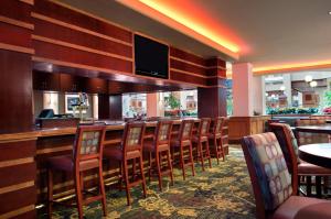 a bar with a bunch of chairs in a restaurant at Embassy Suites Lexington in Lexington