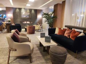 a living room with a couch and chairs and a fireplace at DoubleTree by Hilton London – West End in London +69 photos