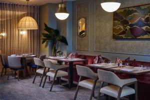 a restaurant with tables and chairs in a room at DoubleTree by Hilton London – West End in London