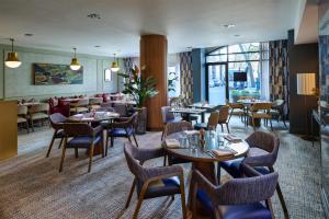 a dining room with tables and chairs and a restaurant at DoubleTree by Hilton London – West End in London