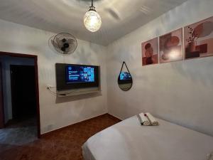 a room with a tv and a bed in a room at Chacara c piscina ampla em Pedro de toledo in Pedro de Toledo +34 photos