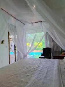 a bedroom with a white bed with a window at Orixás Residence -Casa Yemanja Morro in Cairu