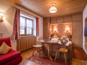 a living room with a desk and a red couch at Maria Rose XXL in Kirchberg in Tirol