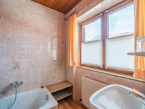 a bathroom with a tub and a sink and a window at Maria Rose XL in Kirchberg in Tirol +23 photos