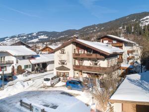 a building with snow on the ground in a town at Maria Rose XL in Kirchberg in Tirol