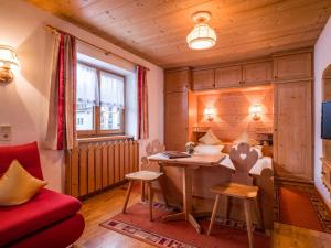 a living room with a desk and a red couch at Maria Rose XL in Kirchberg in Tirol
