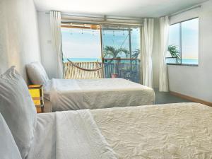 a bedroom with two beds and a view of the ocean at Surf & Sand Lobitos in Lobitos