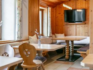 a room with a table and chairs and a tv at Pension Schreder XL in Kirchberg in Tirol
