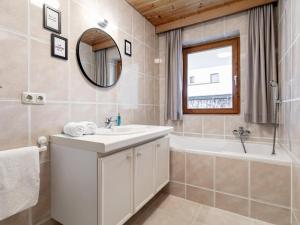 a bathroom with a sink and a tub and a mirror at Pension Schreder XL in Kirchberg in Tirol +32 photos