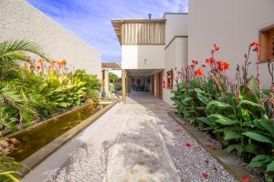 a courtyard of a house with a pond and flowers at Casa Ananda Hotel Boutique in Canoa Quebrada