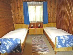 two beds in a room with blue curtains and a window at Chalet Westermeyr in Mieming