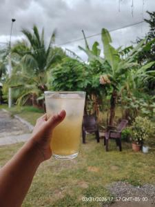 a person holding up a glass of orange juice at Jadash house in David