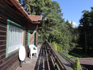 a wooden deck with a white chair on a house at Chalet Westermeyr in Mieming
