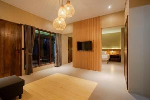 a living room with a tv on a wall at Maheeka Villa, Sanur in Sanur