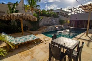 a patio with a table and chairs next to a pool at Casa Ananda Hotel Boutique in Canoa Quebrada